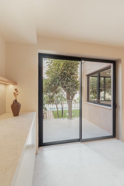 Architectural project - beige walls, refined finish, calm interior, open feel, smooth surface, peaceful space, apartment interior, stone surface, relaxation space, serene vibe, indoor space, architectural detail, natural light, glass, warm tones, natural tones, eco design, neutral tones, daylight, beige, light wood, airy design, urban oasis, simple design, minimalist design, glass doors, contemporary home, indoor outdoor, white, window view, large window, outdoor view, stone, inviting space, garden view, bright space, sliding doors, seamless transition, residential, cozy home, greenery view, sustainable living, modern interior, terrace access, serene home, tranquility, living space, urban retreat, urban living, light flooring