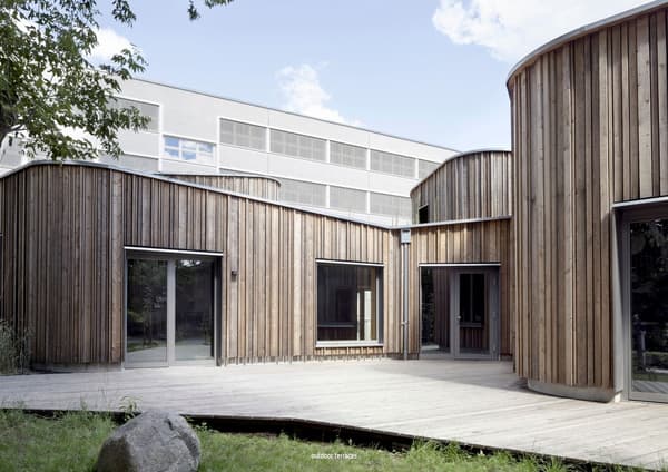 Architectural project - natural materials, wood, timber, raw materials, grey, outdoor space, passive design, sustainable design, warm tones, contemporary architecture, neutral tones, beige, wood facade, timber facade, exterior design, light wood, daylight optimization, Scandinavian influence, timber construction, honey wood, natural textures, minimalist design, tranquil setting, biophilic design, natural ventilation, timber cladding, wood cladding, modern architecture, textured wood, inviting space, garden view, eco-friendly building, green design, exterior wood, wooden deck, educational space, school building, light facade, public building, circular shapes, curved design, courtyard, timber decking, educational architecture, architectural rhythm