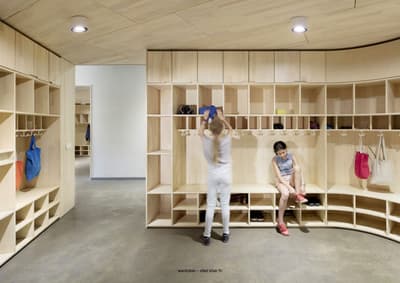Architectural project - minimal design, natural materials, sustainable materials, wood, sustainable design, modular design, eco design, community space, neutral tones, functional space, multi-use space, plywood, beige, light wood, functional design, eco friendly, modern design, Scandinavian style, light tones, clean lines, Nordic design, warm ambiance, wood shelves, inviting space, earthy tones, built-in shelves, bright space, interior design, educational space, hallway, practical design, wardrobe, shelving, storage unit, timber storage, wood storage, shelving unit, wooden shelves, plywood interior, Scandinavian interior, modern interior, organized space, contemporary space, interior architecture, school interior, children's space, educational interior, coat hangers, bags, open shelving, wooden finish, smooth finish, light finishes, circularity, modern wood