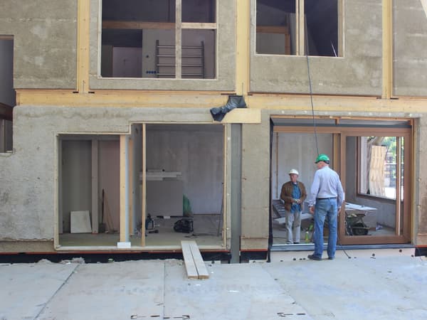 Architectural project - exposed timber, workshop, home build, energy conscious, natural materials, timber, raw materials, timber frame, natural light, sustainable design, glass, green building, grey, neutral tones, construction site, work in progress, construction workers, daylight, construction materials, building site, beige, concrete, light wood, eco friendly, sand, building process, unfinished building, residential construction, sustainable building, eco construction, prefab elements, circular construction, low carbon, passive house, large windows, indoor outdoor, energy efficient, plaster, plaster finish, wooden structure, straw bale, natural insulation