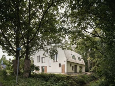 Architectural project - minimal facade, mindful living, plaster facade, woodland home, minimalist, natural light, sustainable design, warm tones, eco design, green, beige, modern design, natural setting, simple design, cozy retreat, neutral palette, Scandinavian vibe, tranquil setting, eco-friendly materials, green architecture, biophilic design, eco home, sustainable home, passive house, landscape integration, Nordic design, rural home, energy efficient, wood accents, plaster, beige tones, green living, earthy tones, environmental design, forest retreat, woodland retreat, nature integration, outdoor harmony, modern home, light facade, neutral, modern cabin, country home