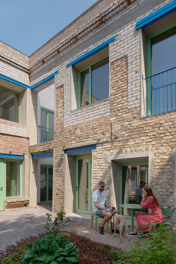Architectural project - green windows, brick wall, garden, plant life, farmhouse modern, urban courtyard, double-story, home exterior, brick cladding, mint green windows, double-storey, multi-level, conversation area, garden plants, mixed finishes, natural materials, relaxed vibe, natural light, outdoor living, sustainable design, warm tones, green, daylight, beige, brown, exterior design, outdoor seating, natural finish, earth tones, eco home, sustainable home, plaster wall, plaster, rustic style, earthy tones, cozy outdoor, terracotta, brick, rustic facade, brick facade, greenery, family home, residential building, modern home, textured facade, home garden, residential use, urban garden, courtyard, welcoming space, renovation, mixed materials
