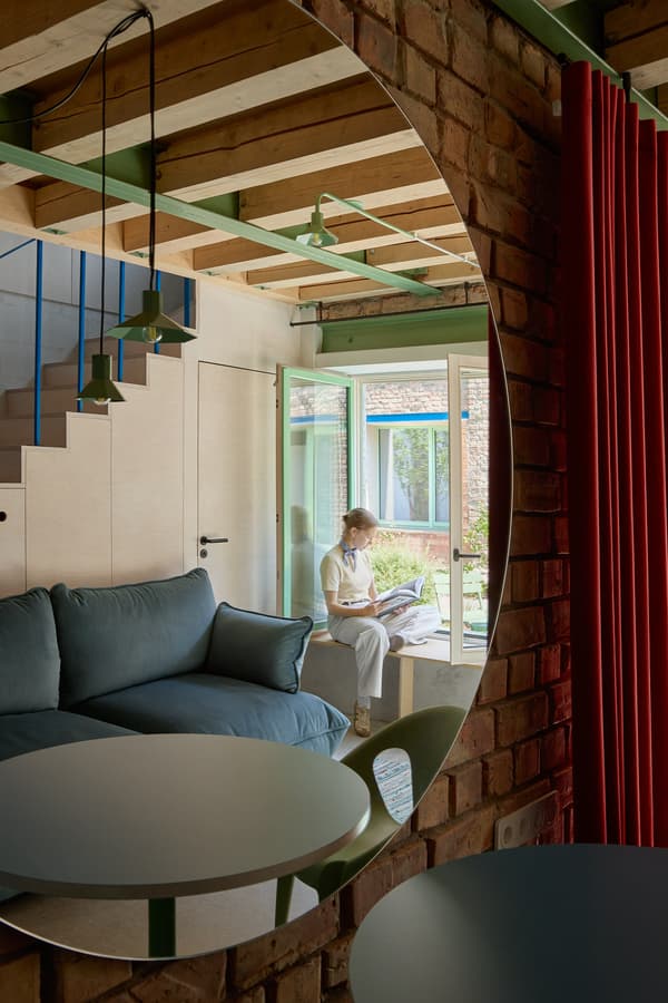 Architectural project - green accents, brick wall, vintage touch, raw textures, exposed brick, pendant lighting, wooden steps, loft vibe, spacious room, modern retro, blue sofa, staircase design, open beams, convivial atmosphere, intimate space, natural materials, serene environment, wood, timber, natural light, glass, neutral tones, beige, functional design, blue, rustic modern, Scandinavian style, neutral palette, calming space, glass doors, pastel green, tranquil setting, modern rustic, eco home, light filled, indoor outdoor, Nordic design, inviting home, energy efficient, timber ceiling, casual living, minimalist decor, earthy tones, warm atmosphere, brick, residential design, cozy corner, red brick, garden view, reading nook, comfortable seating, built-in seating, wood ceiling, family room, structural elements, relaxed space, sustainable living, cozy living room, home retreat, timber steps, red