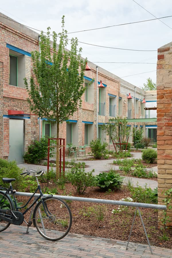 Architectural project - urban greenery, residential complex, pedestrian friendly, city escape, urban revitalization, plant life, landscaped garden, urban courtyard, green courtyard, garden courtyard, communal living, contemporary housing, greenspace, eco urban, bicycle friendly, raw brick, eco community, urban oases, sunny courtyard, livable city, urban planting, relaxing area, light blue accents, urban village, residential greenery, natural materials, outdoor space, natural light, outdoor living, passive design, sustainable design, sustainable architecture, neutral tones, industrial vibe, low carbon design, outdoor seating, biophilic design, landscape integration, eco friendly home, brick facade, red brick, nature integration, green design, open space, modern exterior, community housing, urban garden, apartment building, communal space