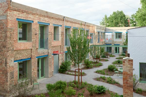 Architectural project - terrace, native plants, urban renewal, brickwork, exposed brick, industrial look, open air space, urban courtyard, masonry, recycled brick, multi-family housing, shared courtyard, eco-friendly architecture, communal area, social housing, eco-conscious living, revitalization project, light gray, natural materials, metal, outdoor space, natural light, outdoor living, passive design, sustainable design, glass, neutral tones, daylight, industrial vibe, urban oasis, rustic charm, low carbon footprint, green architecture, modern rustic, residential development, green living, earthy tones, brick, landscape design, brick facade, red brick, greenery, garden view, green design, seating area, fresh air, garden path, biodiversity, community housing, green roof, environment friendly