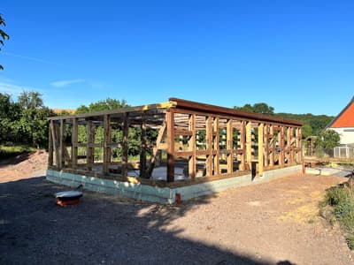 Architectural project - rural landscape, structural frame, architectural structure, framework, wood, timber, raw materials, outdoor space, wooden frame, timber frame, passive design, recycled materials, modular design, sustainable construction, green building, exposed structure, green, construction phase, building framework, construction site, under construction, modern construction, open frame, construction project, brown, natural setting, timber construction, rural architecture, wood beams, timber beams, open framework, eco-friendly materials, blue sky, wood structure, eco build, earthy tones, countryside architecture, environmental design, natural environment, countryside setting