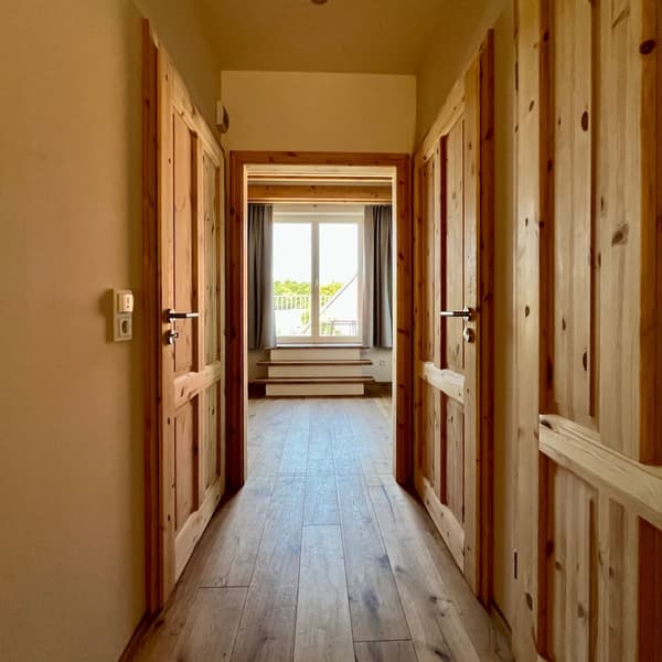 Architectural project - beige walls, wooden doors, wooden features, comfort, cozy entrance, quiet space, simplicity, neutral walls, wood, timber, natural light, rustic touch, sustainable design, neutral tones, daylight, beige, light wood, natural wood, sunlight, simple design, rustic vibe, Scandinavian style, timber floor, wooden floor, eco-friendly materials, light tones, timber panels, Nordic style, warm ambiance, wood texture, minimalist decor, wooden panels, residential space, timeless design, home interior, cozy home, hallway, understated elegance, residential hallway, interior corridor