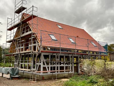 Architectural project - skylights, rustic materials, red tiles, terracotta roof, farmhouse, rooftop, framework, wood, timber, scaffolding, outdoor space, timber frame, natural light, eco design, grey, neutral tones, timber structure, under construction, construction process, building site, brown, open structure, wooden beams, rural architecture, natural textures, open framework, exterior, low carbon, circular design, sustainable home, passive house, landscape integration, Nordic style, countryside home, energy efficient, stone, rustic style, sloped roof, pitched roof, terracotta, stone wall, rural setting, traditional style, earthy palette, renovation, rural house, clay tiles, red, remodel
