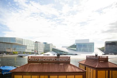 Architectural project - gray, urban renewal, city center, waterfront, city vibes, river view, cultural building, white building, architecture icon, waterfront development, landmark building, glass building, bright setting, modern urban planning, new development, oslo architecture, civic building, cultural hub, scandinavian architecture, vibrant city, urban exploration, leisure area, timber, steel, cityscape, natural light, outdoor area, contemporary architecture, urban landscape, innovative design, daylight, concrete, eco friendly, sunlight, public space, outdoor seating, urban design, blue sky, geometric design, minimalist structure, sustainable building, modern facade, white, Nordic design, green design, outdoor architecture, open space, angular shapes, glass facade, natural surroundings, architectural contrast, modern urban