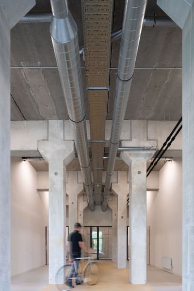 Architectural project - concrete finish, concrete structure, warehouse style, industrial interior, exposed ductwork, loft style, unfinished look, urban loft, modern loft, creative workspace, utility space, industrial design, raw materials, grey tones, steel, metal, natural light, eco design, contemporary style, grey, daylight, beige, concrete, functional design, minimalist vibe, neutral palette, adaptive reuse, industrial chic, sustainable building, circular design, minimal aesthetic, modern architecture, robust design, open plan, spacious interior, open space, airy atmosphere, structural elements, understated elegance, high ceiling, urban living, exposed ceiling, office space
