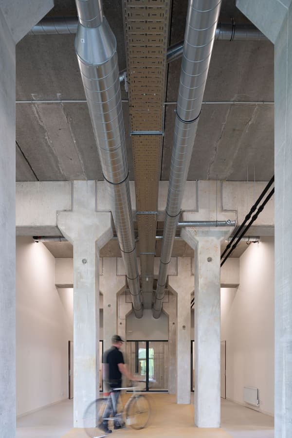 Architectural project - concrete finish, concrete structure, warehouse style, industrial interior, exposed ductwork, loft style, unfinished look, urban loft, modern loft, creative workspace, utility space, industrial design, raw materials, grey tones, steel, metal, natural light, eco design, contemporary style, grey, daylight, beige, concrete, functional design, minimalist vibe, neutral palette, adaptive reuse, industrial chic, sustainable building, circular design, minimal aesthetic, modern architecture, robust design, open plan, spacious interior, open space, airy atmosphere, structural elements, understated elegance, high ceiling, urban living, exposed ceiling, office space
