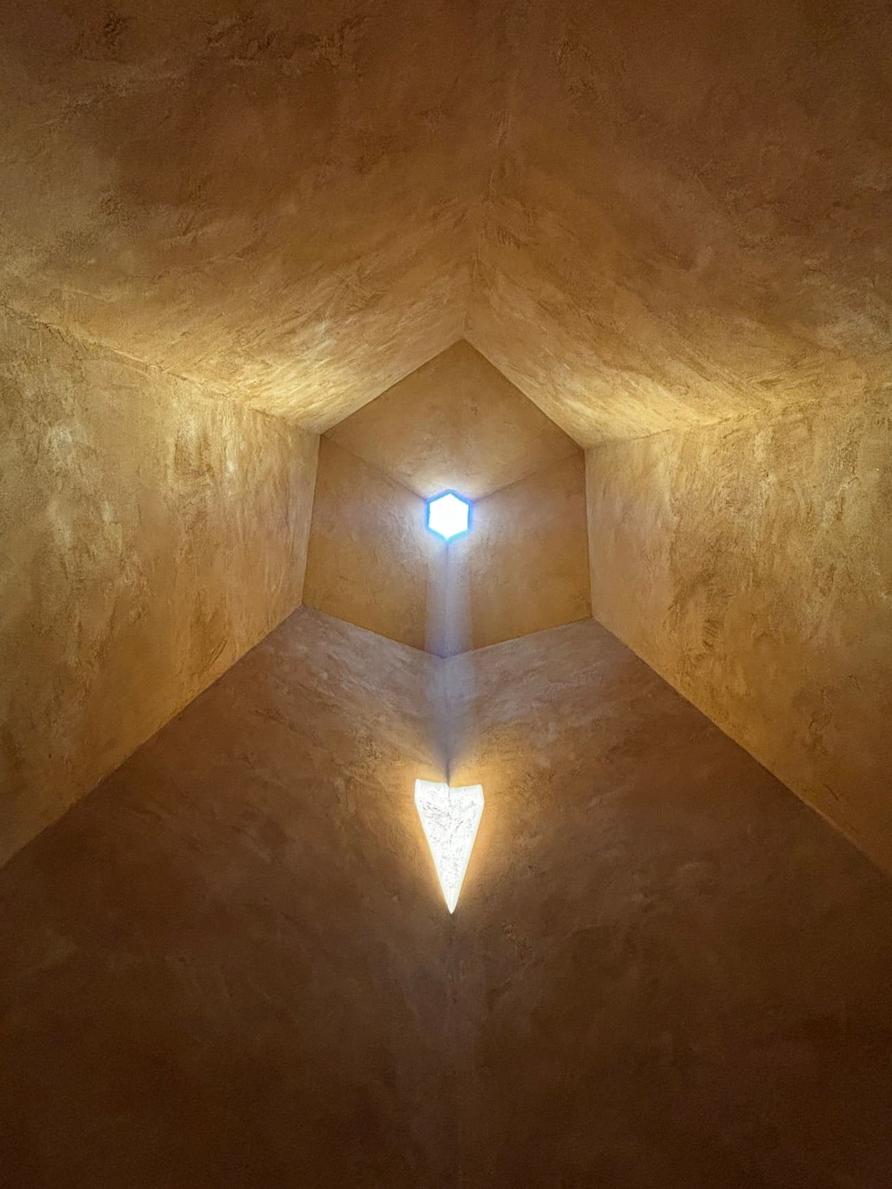 Architectural project - warm glow, soft glow, textured ceiling, plaster ceiling, ceiling light, enclosed space, tranquil design, subtle lighting, geometric ceiling, hexagonal skylight, skylight feature, light well, sculptural ceiling, inviting light, peaceful light, reflective space, ceiling feature, detail lighting, crafted space, all day light, warm interior, intimate space, design focus, natural light, shadow play, organic texture, warm tones, neutral tones, daylight, modern design, simple design, architectural lighting, atmospheric lighting, contemporary design, minimalist design, serene space, calming light, earth tones, plaster, earthy vibe, earthy tones, cozy atmosphere, unique design, light shaft, architectural geometry, architectural feature, architectural element