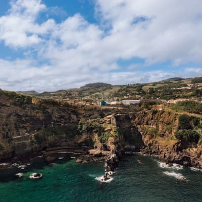 Architectural project - coastal village, coastal landscape, oceanfront, ocean view, sustainable landscape, cliff view, natural scenery, seaside cliffs, rocky coastline, scenic vista, waterside, sea horizon, rural coastline, open sky, cloudy sky, coastal living, tranquil surroundings, vibrant nature, ecofriendly setting, outdoor inspiration, beach cliff, shoreline perspective, coastal charm, maritime atmosphere, wide landscape, nature photography, sea rocks, surf zone, teal water, serene environment, outdoor space, rustic charm, blue sky, earth tones, biophilic design, green landscape, panoramic view, nature escape, lush greenery, natural beauty