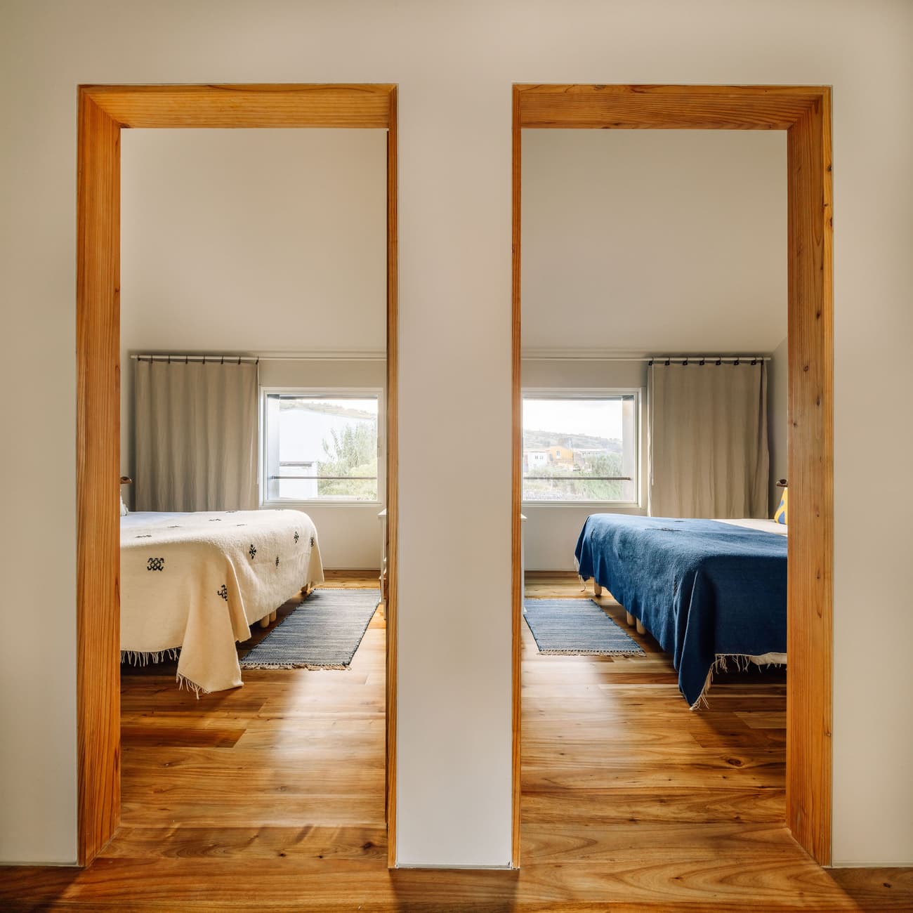 Architectural project - home decor, warm bedroom, double door, open doorway, bedroom view, twin bedroom, dual space, shared space, soft bedding, casual bedding, cozy textiles, wool rug, cotton curtains, relaxing environment, interior walls, home comfort, stylish design, natural materials, wood elements, architectural detail, wooden frame, timber frame, natural light, inviting atmosphere, sustainable design, warm tones, eco design, neutral tones, daylight, light wood, natural wood, eco friendly, simple design, honey wood, rustic modern, timber floor, neutral palette, calming space, serene space, Scandinavian vibe, clean aesthetic, tranquil setting, wood floor, modern rustic, Nordic style, framed view, comfortable home, earthy tones, residential design, peaceful retreat, interior design, cozy bedroom, minimalist bedroom, Japandi style