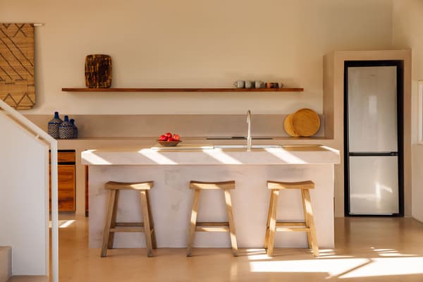 Architectural project - functionality, neutral kitchen, open plan kitchen, wood stools, wooden stools, light wood stools, beige kitchen, shelf decor, built-in fridge, kitchen counter, smooth textures, serene kitchen, ergonomic design, eco-friendly kitchen, subtle elegance, sustainable materials, wood, relaxed vibe, natural light, contemporary style, neutral tones, daylight, beige, light wood, simple design, natural textures, Scandinavian style, clean lines, light filled, Nordic style, plaster, beige tones, cozy kitchen, kitchen storage, family kitchen, home kitchen, bright kitchen, inviting space, minimalist kitchen, modern kitchen, kitchen island, calm atmosphere, plaster walls, minimal decor, open shelving, seamless design, Japandi style