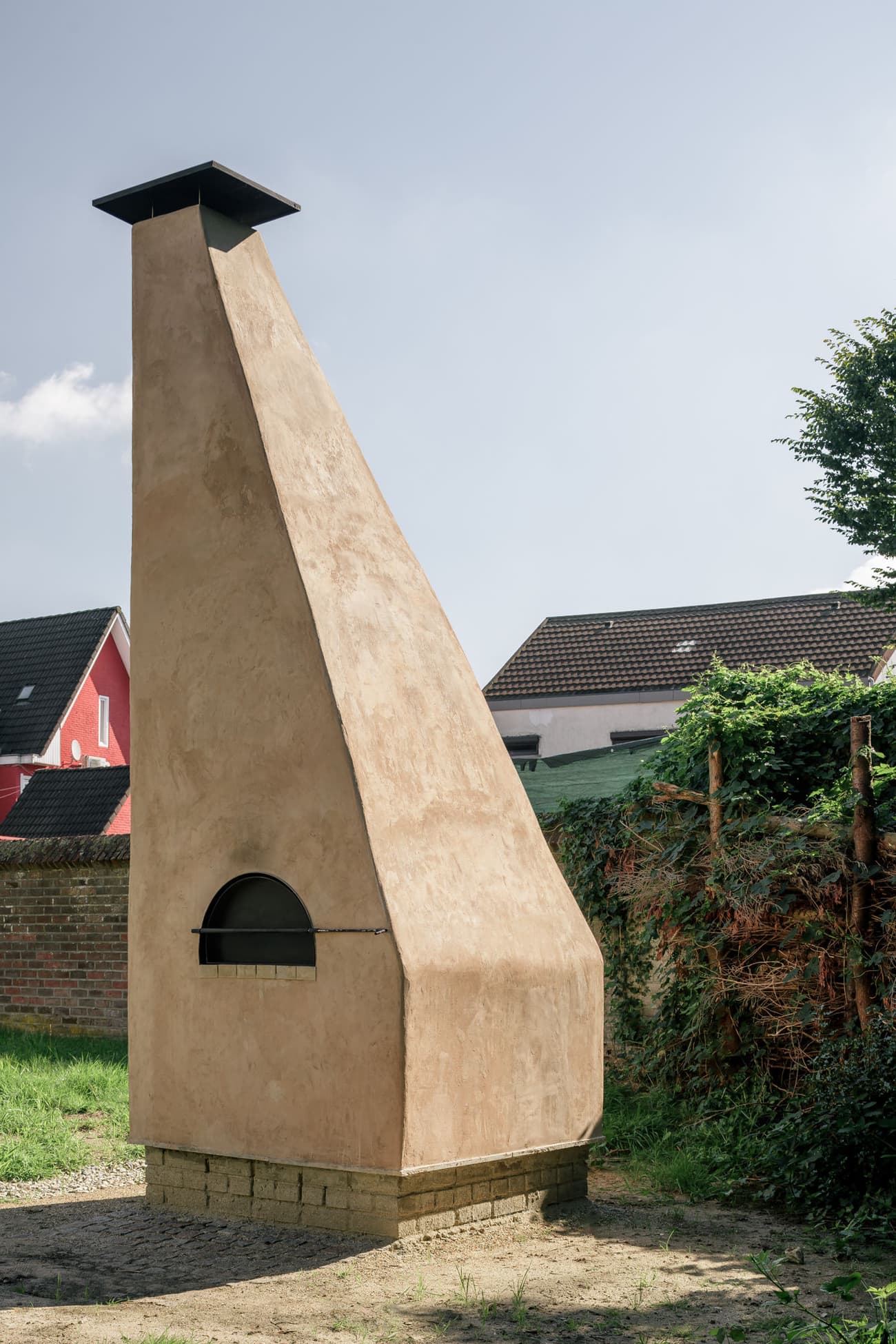 Architectural project - minimal design, natural materials, outdoor living, sustainable design, warm tones, community space, simple structure, outdoor structure, exterior, natural finish, plaster, rough texture, earthy vibe, stonework, earthen design, beige color, chimney, eco-friendly structure, social gathering, pizza oven, outdoor cooking, outdoor kitchen, clay oven, traditional oven, clay, adobe oven, backyard feature, rustic oven, plaster finish, garden feature, terracotta, terracotta texture, adobe, brick base, traditional craftsmanship, artisanal design, rural setting, countryside, garden enhancement, cozy corner, landscape design, Mediterranean feel, handmade aesthetic, functional sculpture, outdoor element, craftmanship