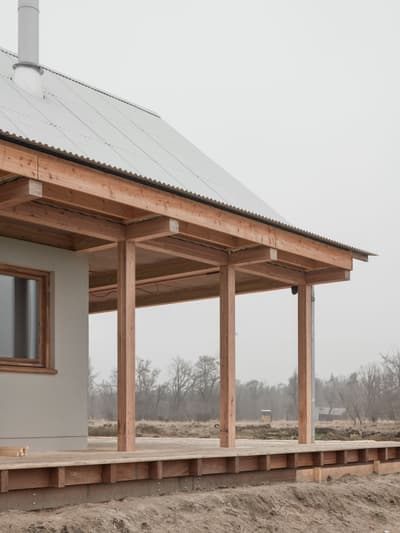 Architectural project - modern farmhouse, quiet setting, veranda, natural materials, wood, metal, outdoor space, outdoor living, passive design, sustainable design, warm tones, corrugated roof, grey, neutral tones, structural timber, beige, brown, wood facade, timber facade, natural wood, rural architecture, simple design, serene atmosphere, minimalist architecture, minimalist design, eco materials, wood structure, modern rustic, open landscape, eco home, natural ventilation, metal roof, clean lines, timber cladding, wood cladding, timber house, countryside home, landscape view, pitched roof, rural setting, exterior view, country vibe, earthy palette, gabled roof, inviting exterior, rural house