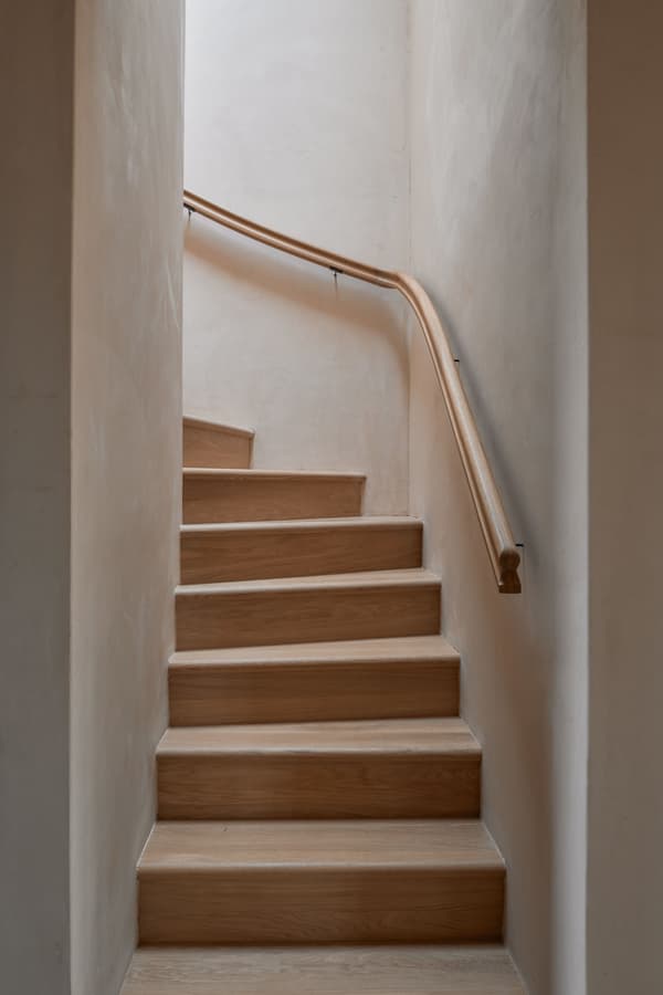 Architectural project - minimalist stairs, subtle design, oak wood, timber stairs, matte finish, intimate space, natural materials, architectural detail, soft lighting, serene environment, eco-friendly design, timber, warm tones, neutral tones, beige, light wood, functional design, compact space, simple design, peaceful setting, minimalist style, calming space, sustainable home, simple elegance, Nordic design, cozy vibe, inviting home, plaster, warm atmosphere, natural texture, textured walls, warm light, Scandinavian design, plaster walls, soft tones, home interior, oak, wooden stairs, clean design, smooth finish, Japandi style, staircase, residential interior
