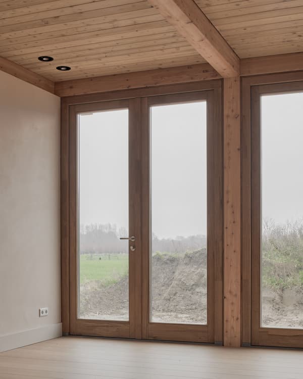 Architectural project - warm vibes, light filled room, natural view, seamless connection, cozy interior, warm interior, calming atmosphere, natural materials, eco-friendly design, wood, natural light, rustic touch, sustainable design, warm tones, natural tones, sustainable architecture, neutral tones, exposed beams, daylight, beige, brown, modern design, honey wood, natural textures, Scandinavian style, minimalist design, serene space, warm wood, biophilic design, eco home, passive house, large windows, indoor outdoor, Nordic style, landscape view, energy efficient, earthy materials, plaster, timber ceiling, timber interior, inviting space, textured walls, minimalist space, bright interior, glass door, wooden frames, plaster walls, cozy vibes, wood ceiling, warm lighting, clean design, connection with nature, timber door, wooden door, wood interior
