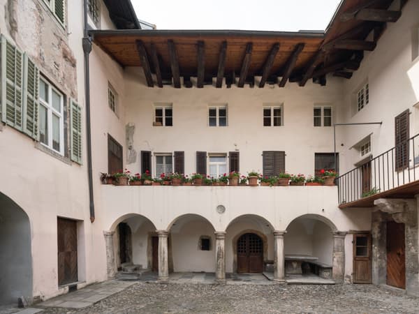 Architectural project - wooden shutters, rustic elegance, terracotta pots, period architecture, cultural heritage, old-world charm, residential courtyard, Southern European, classic design, traditional materials, vintage charm, traditional facade, outdoor courtyard, historic courtyard, courtyard architecture, arched colonnade, stone arches, stone pavement, cobblestone courtyard, villa courtyard, balcony details, flower pots, heritage restoration, wood, warm tones, neutral tones, exposed beams, beige, brown, wooden beams, natural textures, rustic charm, simple elegance, white, stone, plaster, inviting space, earthy tones, warm atmosphere, Mediterranean style, cozy outdoor, terracotta, classic architecture, heritage building, timeless design, plaster walls, exterior space