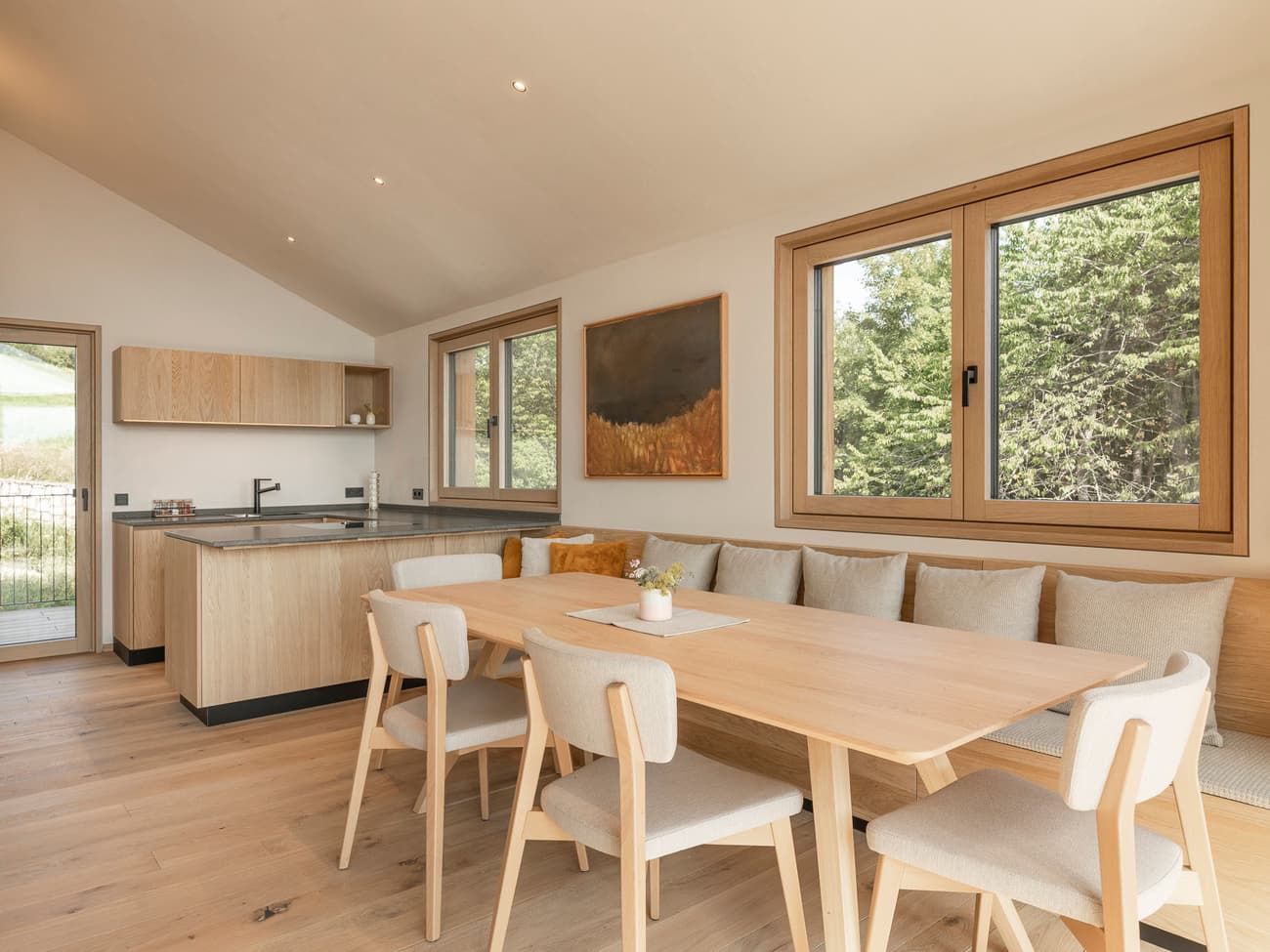 Architectural project - airy interior, family dining, cozy dining, wood table, wood chairs, cream, relaxing vibe, nature views, tranquil home, harmonious space, open kitchen, wood, timber, natural light, warm tones, eco design, daylight, beige, light wood, honey wood, rustic modern, natural textures, Scandinavian style, timber floor, wooden floor, neutral palette, calming space, modern rustic, biophilic design, sustainable home, contemporary home, large windows, Nordic design, beige tones, open layout, open plan, dining area, inviting space, warm atmosphere, casual dining, comfortable seating, residential space, bright interior, minimalist kitchen, modern kitchen, wood cabinetry, timber cabinetry, breakfast nook, interior, seamless transition, home interior, understated elegance