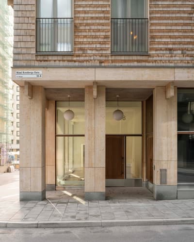 Architectural project - urban building, geometric lines, vertical lines, bright facade, grid pattern, mixed-use building, natural materials, architectural detail, sustainable materials, wood, timber, passive design, glass, warm tones, eco design, grey, neutral tones, city architecture, beige, concrete, wood facade, light wood, daylight optimization, Scandinavian style, minimalist design, glass doors, low carbon, modern facade, clean lines, large windows, simple elegance, Nordic design, energy efficient, inviting entrance, natural texture, environmental design, timber exterior, shingle cladding, warm exterior, pale wood, glass facade, structural rhythm, urban facade, urban style, urban modern, contemporary building
