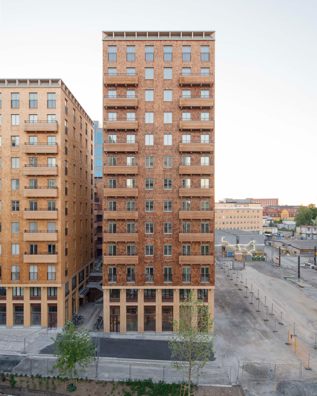 Architectural project - residential complex, urban renewal, brick exterior, multi-family housing, brick cladding, high rise, mixed-use building, city planning, bricks, natural materials, city living, metal, cityscape, natural light, glass, eco design, urban landscape, sustainable architecture, grey, neutral tones, urban development, beige, brown, concrete, structural design, low carbon design, daylight optimization, contemporary design, modern facade, timber accents, brick facade, exterior view, residential building, balcony design, community housing, apartment building, efficient design, street view, urban housing, modern city