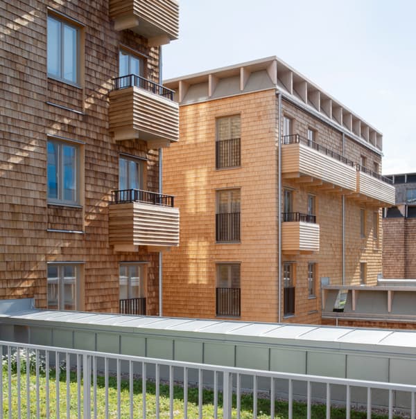 Architectural project - urban greenery, rooftop terrace, contemporary housing, community living, multi-family housing, eco-friendly architecture, wooden balcony, cladding detail, natural materials, timber, outdoor space, passive design, sustainable design, warm tones, beige, wood facade, timber facade, light wood, daylight optimization, honey wood, Scandinavian style, urban design, natural ventilation, landscape integration, energy efficient, cedar shingles, natural aesthetics, greenery, residential building, nordic influence, facade design, low carbon building, urban context, architectural harmony, texture contrast, urban housing, modern residential