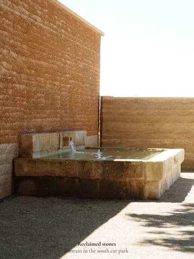 Architectural project - natural integration, rustic courtyard, rustic elegance, earthy aesthetic, simple landscaping, ecological architecture, minimalist landscape, stone fountain, courtyard fountain, outdoor fountain, reclaimed stone, desert vibes, arid landscape, zen garden, heritage materials, calming atmosphere, natural materials, sustainable design, warm tones, eco friendly, natural textures, organic design, neutral palette, serene space, passive cooling, rammed earth, green architecture, biophilic design, textured wall, stonework, earthy tones, environmental design, peaceful retreat, landscape design, water feature, outdoor retreat, outdoor relaxation, architectural feature