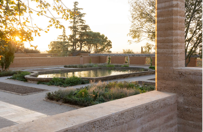 Architectural project - garden architecture, heritage design, rustic landscape, earth wall, terracotta walls, peaceful garden, garden courtyard, natural courtyard, reflective pool, mediterranean garden, mediterranean landscape, sunset view, classic landscape, architectural garden, historical influence, planting design, outdoor ambiance, sustainable courtyard, outdoor space, sustainable design, warm tones, eco design, exterior design, natural setting, rustic charm, serene space, outdoor seating, rammed earth, biophilic design, textured wall, stone, earthy tones, clay, environmental design, landscape design, greenery, tranquil atmosphere, sunlit, nature integration, open air, outdoor harmony, timeless design, water feature, courtyard, low impact design, outdoor relaxation