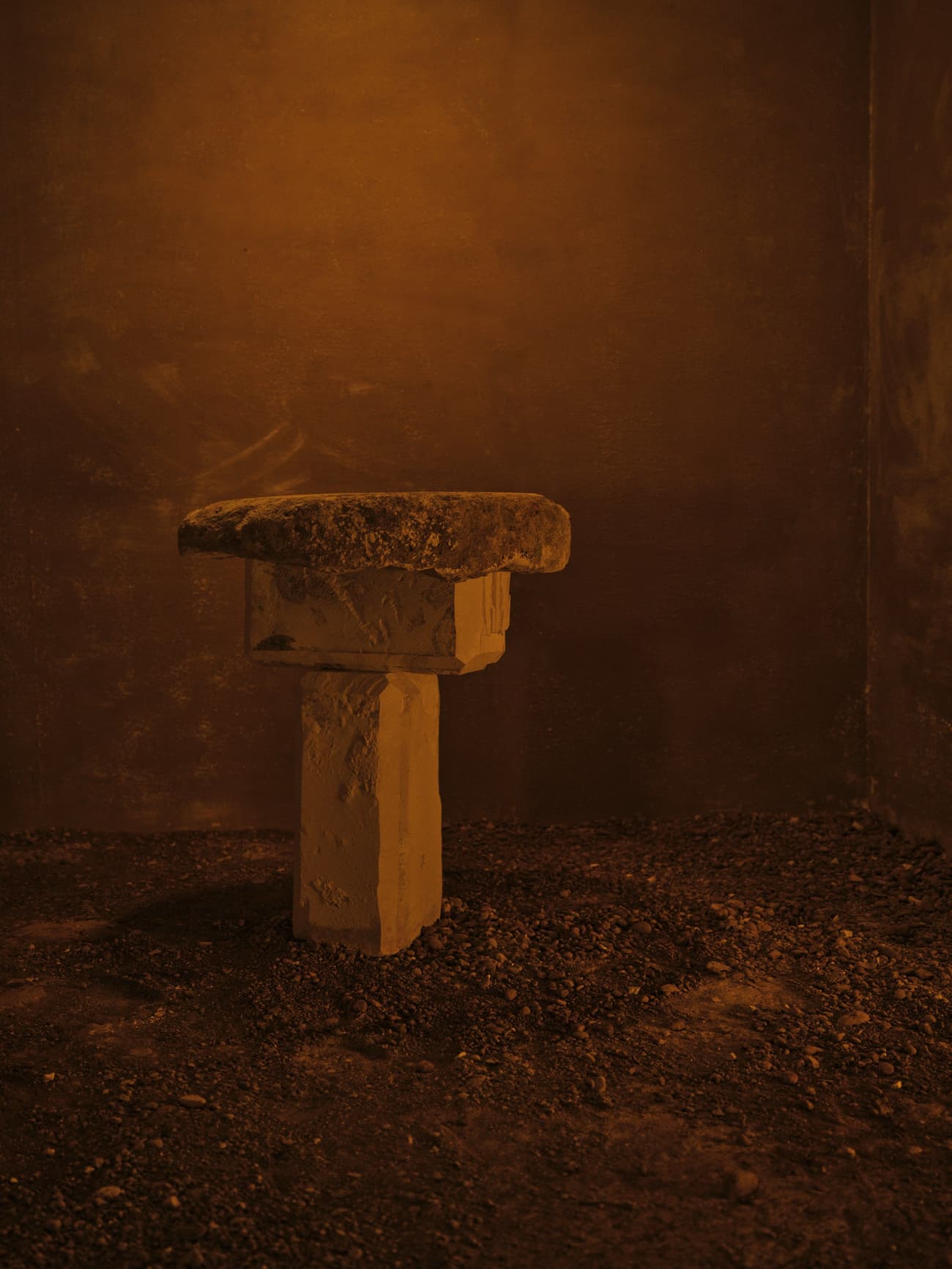 Architectural project - textured stone, historical vibe, ambient lighting, dim lighting, secluded space, monolithic altar, ancient altar, rustic altar, stone pedestal, aged stone, rough stone, dramatic lighting, mystical atmosphere, ancient vibe, meditation spot, spiritual corner, sacred space, primal design, earthy setup, subdued colors, earth material, ritual area, ceremonial space, art installation, sculptural element, mood lighting, museum display, cultural artifact, heritage piece, stone material, amber, ancient texture, minimal design, indoor space, warm tones, beige, brown, natural material, warm ambiance, rough texture, earthy tones, textured finish, raw finish, warm lighting