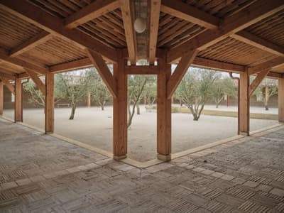 Architectural project - pergola, timber posts, shaded area, textured flooring, open courtyard, covered patio, earthy design, wood columns, natural landscaping, sandy ground, rustic flooring, semi-outdoor, natural materials, architectural design, wood, timber, relaxation area, outdoor space, natural light, outdoor living, sustainable design, warm tones, eco design, community space, exposed beams, timber structure, wooden ceiling, gathering space, beige, brown, light wood, eco friendly, timber beams, neutral palette, sand, wood structure, biophilic design, landscape integration, timber ceiling, rustic style, inviting space, warm atmosphere, rustic design, Mediterranean style, cozy outdoor, greenery, patio area, courtyard, trees