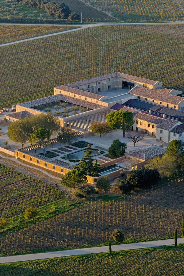 Architectural project - stone walls, tiled roof, historic building, terracotta roof, olive trees, classic design, vineyard estate, vineyard rows, sustainable agriculture, stone building, vineyard view, mediterranean architecture, rural estate, aerial shot, agricultural landscape, sprawling estate, farm estate, central courtyard, geometric layout, agricultural fields, eco-friendly farm, historic charm, estate grounds, green spaces, plantation, timeless elegance, heritage property, serene environment, green, beige, brown, rural architecture, rustic vibe, rustic charm, tranquil setting, earth tones, open landscape, scenic view, stone, traditional architecture, terracotta, countryside, landscape design, traditional style, countryside retreat, pastoral scene, courtyard
