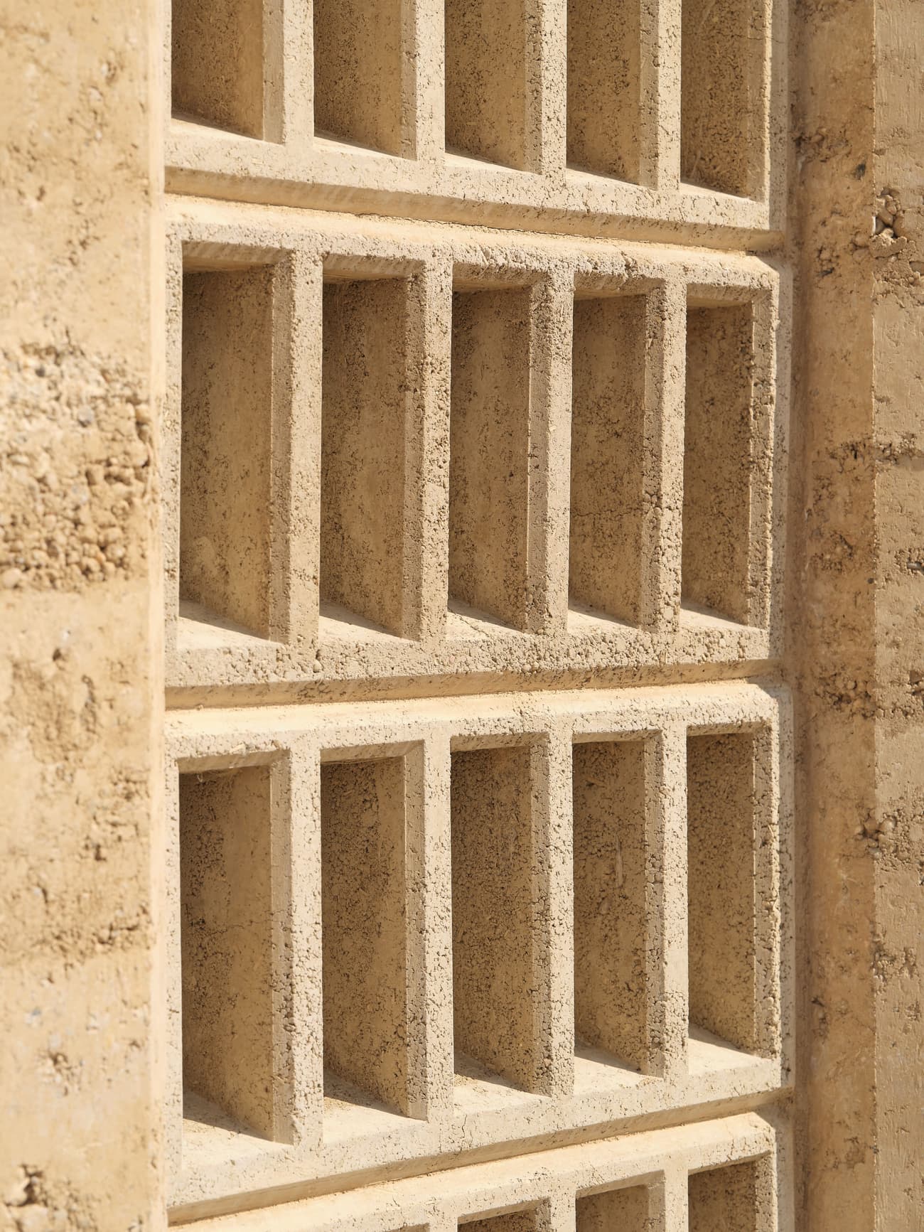 Architectural project - earth wall, grid pattern, earthy design, natural structure, desert tones, sand color, texture detail, minimal design, architectural detail, natural light, shadow play, rustic touch, passive design, sustainable design, warm tones, sustainable architecture, neutral tones, beige, geometric pattern, exterior wall, eco friendly, sunlight, facade detail, rammed earth, rammed earth wall, natural material, earthy texture, earth tones, earth construction, biophilic design, modern facade, clean lines, textured wall, energy efficient, rustic design, rustic wall, eco material, sustainable material, wall texture, structural rhythm