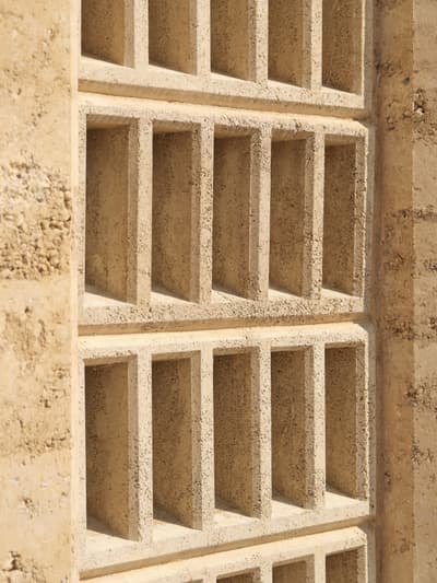 Architectural project - earth wall, grid pattern, earthy design, natural structure, desert tones, sand color, texture detail, minimal design, architectural detail, natural light, shadow play, rustic touch, passive design, sustainable design, warm tones, sustainable architecture, neutral tones, beige, geometric pattern, exterior wall, eco friendly, sunlight, facade detail, rammed earth, rammed earth wall, natural material, earthy texture, earth tones, earth construction, biophilic design, modern facade, clean lines, textured wall, energy efficient, rustic design, rustic wall, eco material, sustainable material, wall texture, structural rhythm