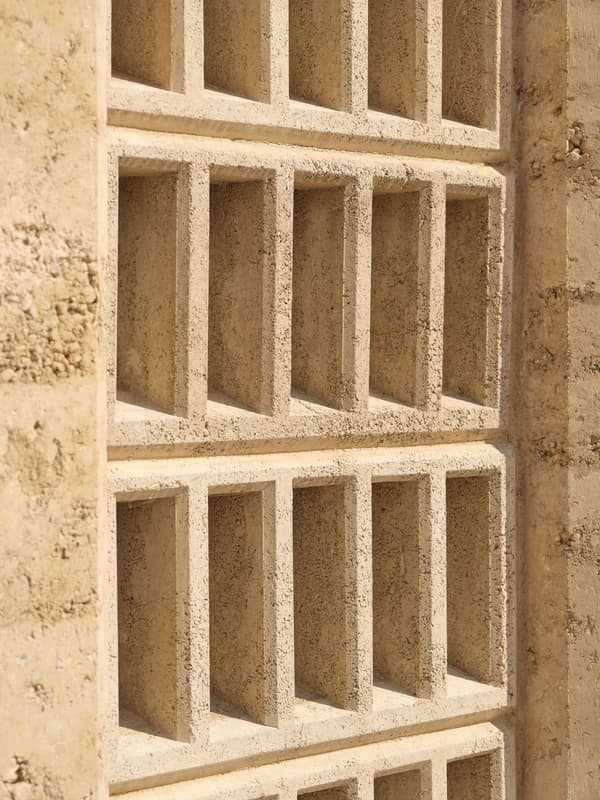 Architectural project - earth wall, grid pattern, earthy design, natural structure, desert tones, sand color, texture detail, minimal design, architectural detail, natural light, shadow play, rustic touch, passive design, sustainable design, warm tones, sustainable architecture, neutral tones, beige, geometric pattern, exterior wall, eco friendly, sunlight, facade detail, rammed earth, rammed earth wall, natural material, earthy texture, earth tones, earth construction, biophilic design, modern facade, clean lines, textured wall, energy efficient, rustic design, rustic wall, eco material, sustainable material, wall texture, structural rhythm