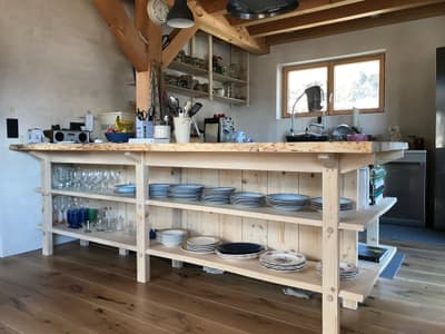 Architectural project - breakfast bar, everyday living, homey atmosphere, inviting kitchen, country kitchen, simple shelves, warm interior, natural materials, wood, timber, natural light, cottage feel, exposed beams, beige, light wood, farmhouse style, timber beams, rustic charm, neutral colors, light tones, cozy vibe, plaster, home kitchen, airy space, earthy tones, casual dining, handcrafted look, relaxed setting, wooden flooring, kitchen island, plaster walls, wood ceiling, minimal decor, functional kitchen, open shelving, rustic kitchen