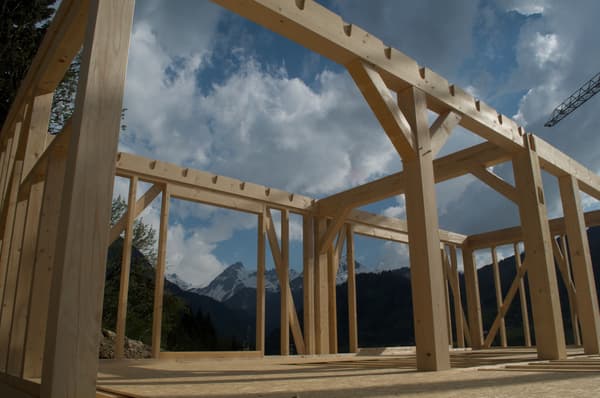 Architectural project - mountain view, scenic backdrop, prefabricated design, timber columns, rustic setting, timber posts, structural frame, natural materials, wood, timber, raw materials, natural light, sustainable design, modular design, sustainable construction, contemporary architecture, neutral tones, exposed beams, modern construction, daylight, outdoor construction, light wood, natural wood, unfinished structure, low carbon design, natural setting, wooden beams, sunlight, timber construction, honey wood, prefab construction, minimal structure, eco building, exterior framework, wood structure, green architecture, biophilic design, wood frame, beige tones, timber framing, clear sky