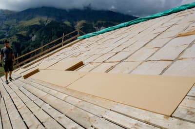 Architectural project - mountain view, green tarp, rustic setting, wooden planks, mountain backdrop, residential project, wood, timber, raw materials, outdoor space, passive design, sustainable design, natural tones, eco design, green building, green, construction site, modern construction, plywood, outdoor construction, construction process, building site, beige, brown, eco friendly, light brown, roof construction, natural landscape, timber roof, scenic view, panoramic view, sloped roof, pitched roof, wooden roof, environmental design, rural setting, natural environment, open space, timber decking, architectural process, home renovation