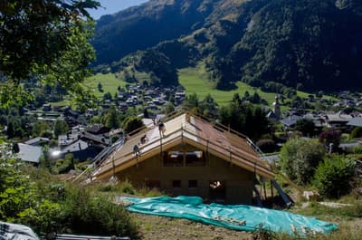 Architectural project - ecological home, forest backdrop, open surroundings, scenic setting, nature views, hillside home, home building, natural materials, wood, timber, sustainable design, green building, under construction, construction process, building site, landscape architecture, wooden beams, timber construction, rural architecture, rustic vibe, outdoor, exterior, tranquil setting, eco building, residential construction, blue sky, framing, natural landscape, low carbon, modern rustic, biophilic design, sustainable home, scenic view, wood frame, panoramic view, pitched roof, rural setting, countryside, nature integration, countryside living, cabin style, wooden structure, passive solar, cozy home