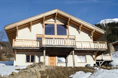 Architectural project - beige facade, mountain retreat, rustic elegance, vernacular style, open balcony, eco lodge, wooden balcony, idyllic setting, natural materials, wood, timber, warm tones, neutral tones, exposed beams, beige, brown, timber facade, timber beams, rustic charm, serene atmosphere, cozy retreat, scenic view, countryside home, outdoor view, plaster, rustic cabin, earthy tones, sloped roof, traditional architecture, natural aesthetics, environmentally friendly, gable roof, nature escape, sustainable cabin, peaceful vibe, wooden facade, vacation home, plaster walls, wooden structure, natural surroundings