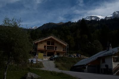 Architectural project - mountain retreat, remote living, natural backdrop, getaway cabin, retreat home, environmental integration, natural materials, wood, timber, scaffolding, outdoor living, passive design, sustainable design, warm tones, green building, beige, brown, timber facade, timber construction, rural architecture, serene atmosphere, exterior, warm wood, hillside house, scenic view, wood cladding, rural home, countryside home, rustic cabin, earthy tones, pitched roof, forest setting, nature retreat, gable roof, wooden facade, eco retreat, wooden structure, cozy vibes, construction, natural surroundings