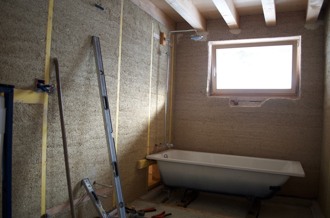 Architectural project - unfinished look, natural bathroom, rustic bathroom, cozy bathroom, small bathroom, earthy walls, bathroom, bathtub, indoor space, natural materials, sustainable materials, wood, timber, timber frame, natural light, eco design, sustainable construction, green building, neutral tones, construction site, work in progress, exposed beams, beige, light wood, eco friendly, compact space, wooden beams, rustic vibe, natural textures, ecological design, passive house, cozy vibe, energy efficient, timber ceiling, rustic style, earthy tones, textured walls, warm light, warm vibe, raw finish, wood ceiling, wooden accents, renovation, skylight, home renovation, remodel