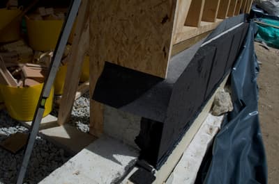 Architectural project - resource efficient, sustainable practice, OSB board, structural frame, natural materials, architectural detail, sustainable materials, timber frame, recycled materials, warm tones, green building, construction phase, timber structure, construction site, assembly process, site work, plywood, construction process, beige, light wood, wood construction, low carbon footprint, construction details, eco construction, exposed wood, building foundation, building materials, foundation work, timber cladding, wood frame, eco-friendly building, wall assembly, wood paneling