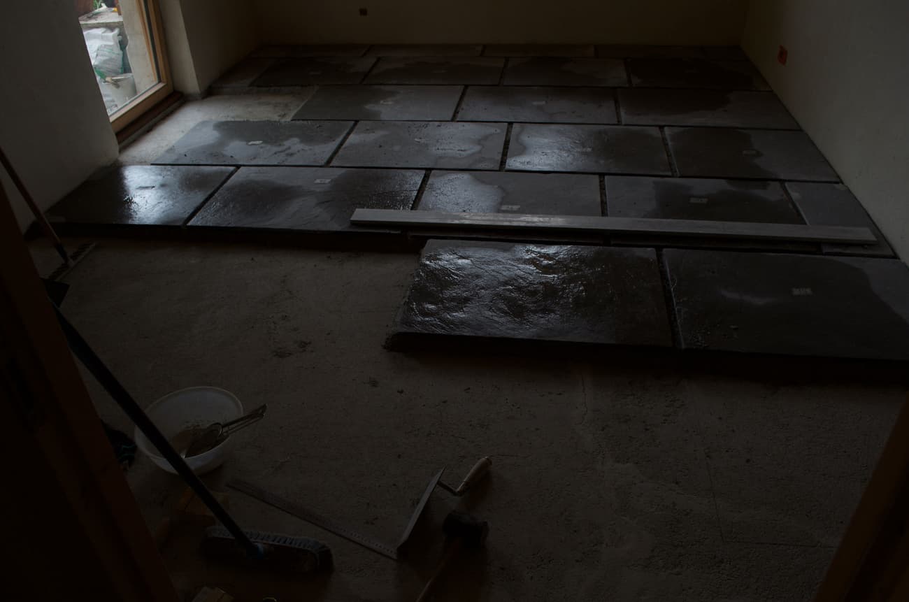 Architectural project - natural stone, renovation process, natural elements, concrete texture, rough surface, rustic floor, construction zone, construction tools, renovation site, indoor space, grey tones, raw materials, neutral tones, construction phase, work in progress, under construction, modern construction, industrial vibe, structural work, concrete, earthy materials, stone, stone tiles, stone floor, dark tiles, concrete slabs, renovation, stone texture