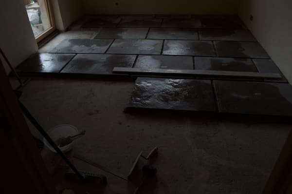 Architectural project - natural stone, renovation process, natural elements, concrete texture, rough surface, rustic floor, construction zone, construction tools, renovation site, indoor space, grey tones, raw materials, neutral tones, construction phase, work in progress, under construction, modern construction, industrial vibe, structural work, concrete, earthy materials, stone, stone tiles, stone floor, dark tiles, concrete slabs, renovation, stone texture