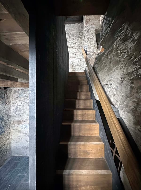 Architectural project - interior stair, exposed stone, heritage design, rustic interior, muted colors, historic building, vintage feel, atmospheric space, rustic stairs, timber stairs, moody atmosphere, intimate space, architectural detail, wood, timber, raw materials, grey tones, warm tones, natural tones, grey, beige, brown, rustic vibe, rustic modern, rustic charm, industrial touch, cozy space, natural finish, warm wood, plaster wall, stone, plaster, earthy tones, stone wall, cozy corner, textured walls, renovation, dark tones, stone texture, remodel