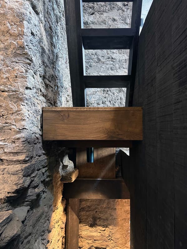 Architectural project - interior stair, exposed stone, wooden steps, heritage conservation, medieval style, vintage charm, wood stair, rugged look, cozy interior, intimate space, natural materials, architectural detail, wood, timber, raw materials, grey tones, natural light, sustainable design, reclaimed materials, warm tones, beige, brown, compact space, timber beams, rustic charm, industrial touch, minimalist design, structural wood, cozy vibe, textured wall, stone, earthy tones, rustic design, stone wall, heritage building, grey stone, eco architecture, architectural contrast, organic textures, dark wood, artisan craft, timber stair, stone texture