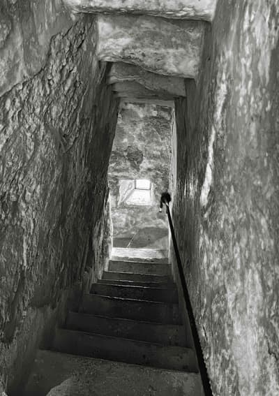 Architectural project - passageway, stone walls, old-world charm, architectural heritage, low light, enclosed space, rustic walls, narrow space, heritage site, aged stone, ancient vibe, rustic stairs, dark atmosphere, weathered stone, historical architecture, monochrome, historical site, stair railing, heritage restoration, grey, neutral tones, rustic charm, stone, rough texture, excavation site, timeless design, stone texture