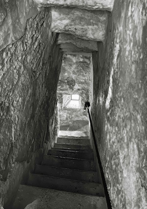 Architectural project - passageway, stone walls, old-world charm, architectural heritage, low light, enclosed space, rustic walls, narrow space, heritage site, aged stone, ancient vibe, rustic stairs, dark atmosphere, weathered stone, historical architecture, monochrome, historical site, stair railing, heritage restoration, grey, neutral tones, rustic charm, stone, rough texture, excavation site, timeless design, stone texture